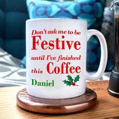 A personalised Christmas mug with the text "don't ask me to be festive until I've finished this coffee" printed on it