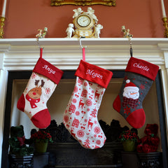 3 personalised Christmas stockings hanging on a mantle piece