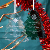 Two personalised "new home" Christmas decorations in a tree shape. One is made from clear acrylic and one is made from green acrylic.