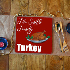 A personalised square placemat with the words "the Smith family turkey" in white lettering on a red background. The is an illustration of a Christmas turkey.