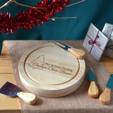 A round wooden cheese board with a Christmas tree and the words "Christmas Cheese Board" engraved on the top.
