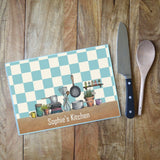A personalised chopping board with an illustration featuring kitchen items and the words "Sophie's Kitchen"