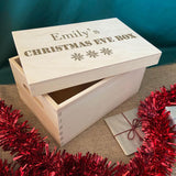 A personalised wooden Christmas Eve box filled with small gifts.