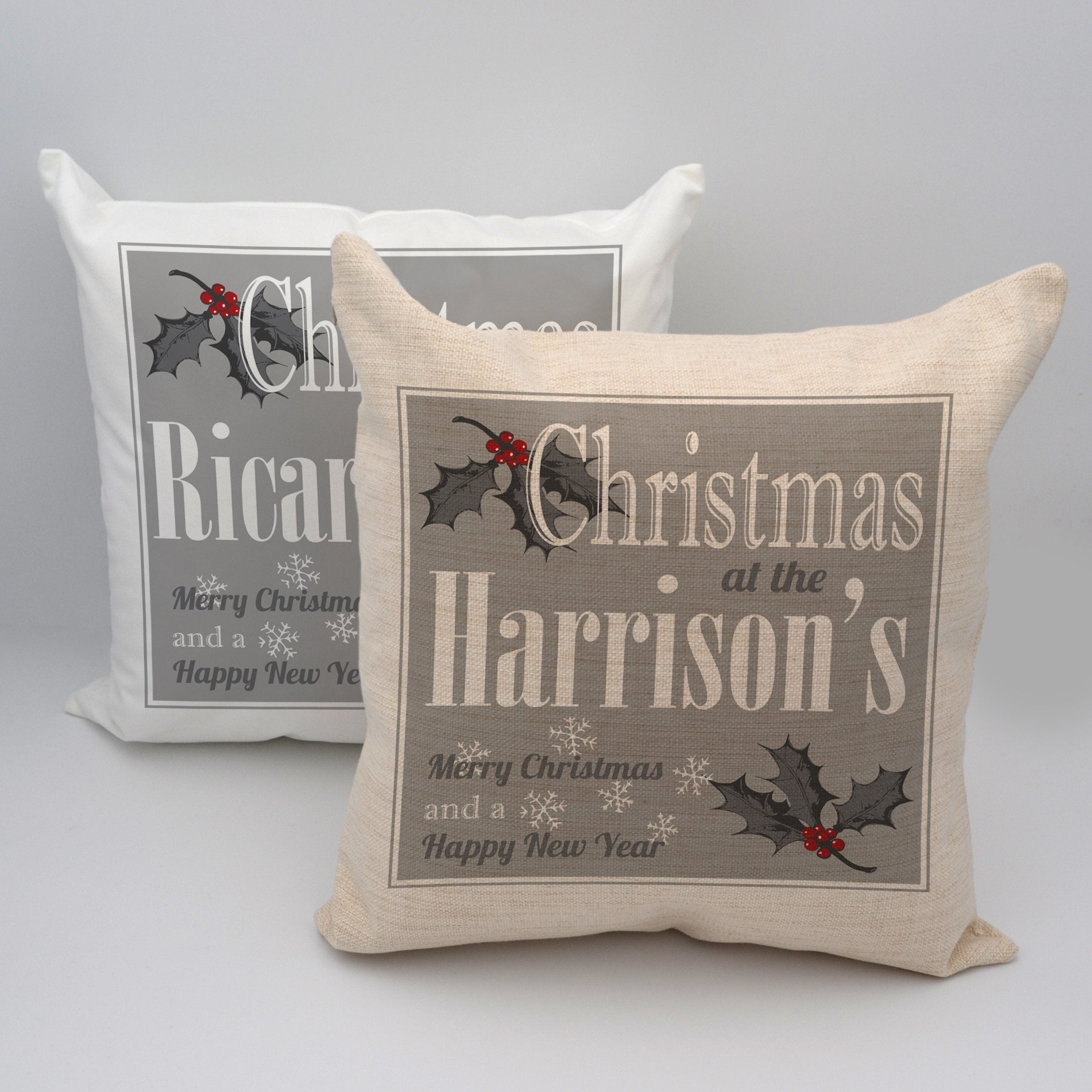 A personalised white, grey and red Christmas cushion with a text based design and holly leaf illustrations