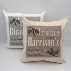 A personalised white, grey and red Christmas cushion with a text based design and holly leaf illustrations
