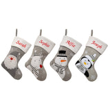 4 personalised Christmas stockings with different characters on them, one with a snowman, one with a penguin, one with a reindeer and one with Santa. All the stockings are embroidered with a name. 