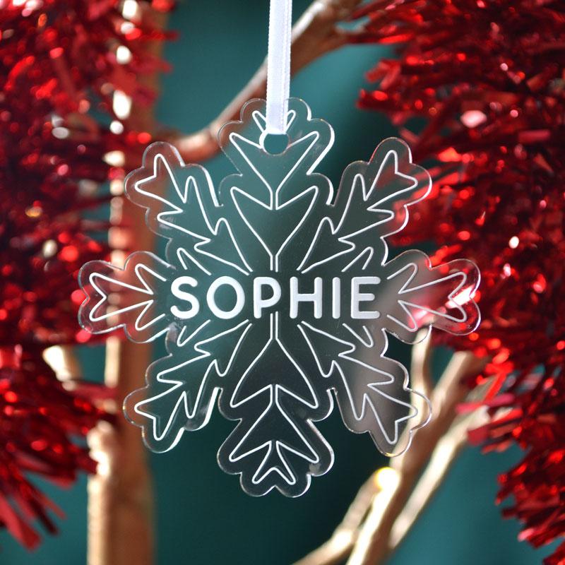 A personalised snowflake shaped Christmas decoration with the name "Sophie" engraved on the front