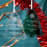 Two personalised "new home" Christmas decorations in a tree shape. One is made from clear acrylic and one is made from green acrylic.